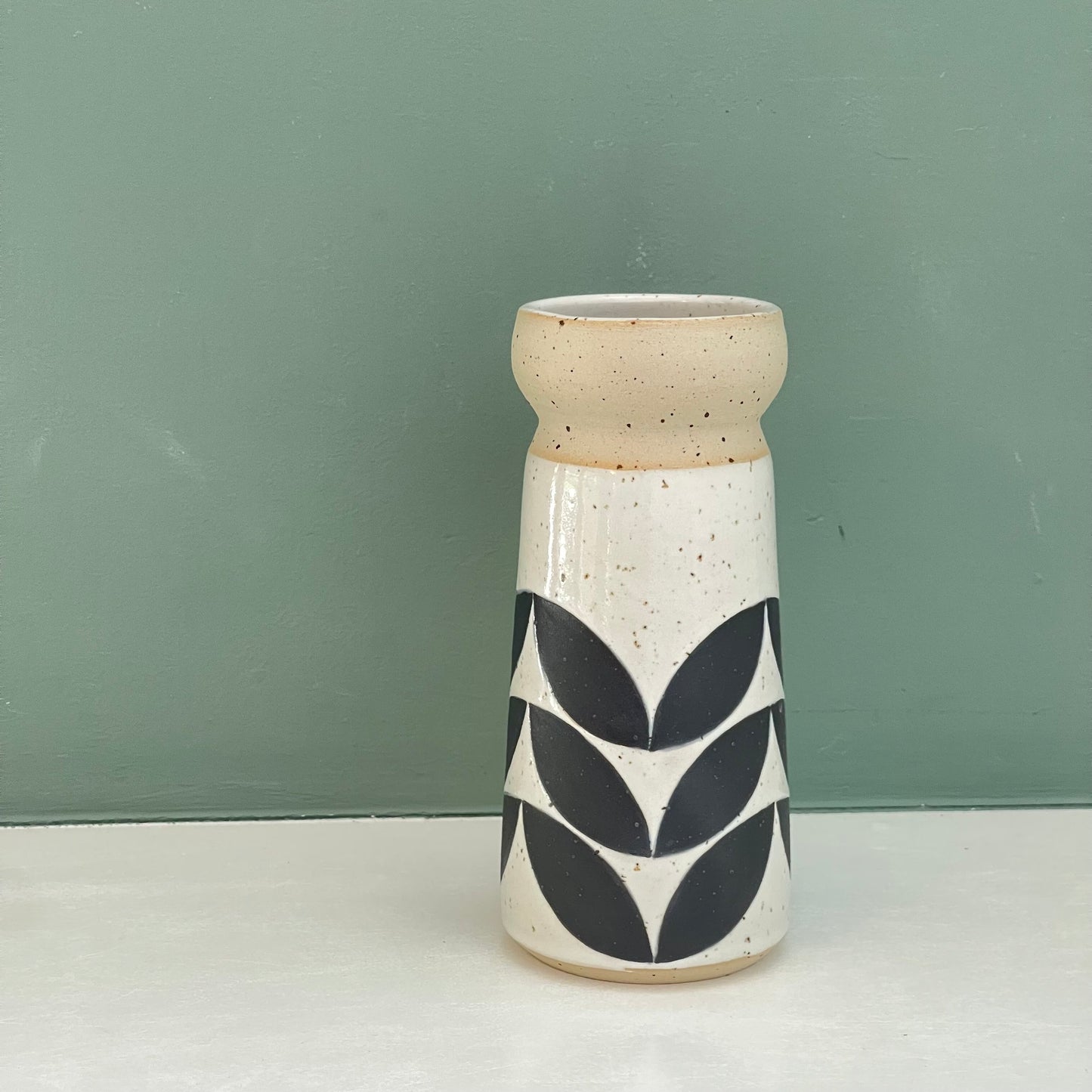 small vase, black leaves