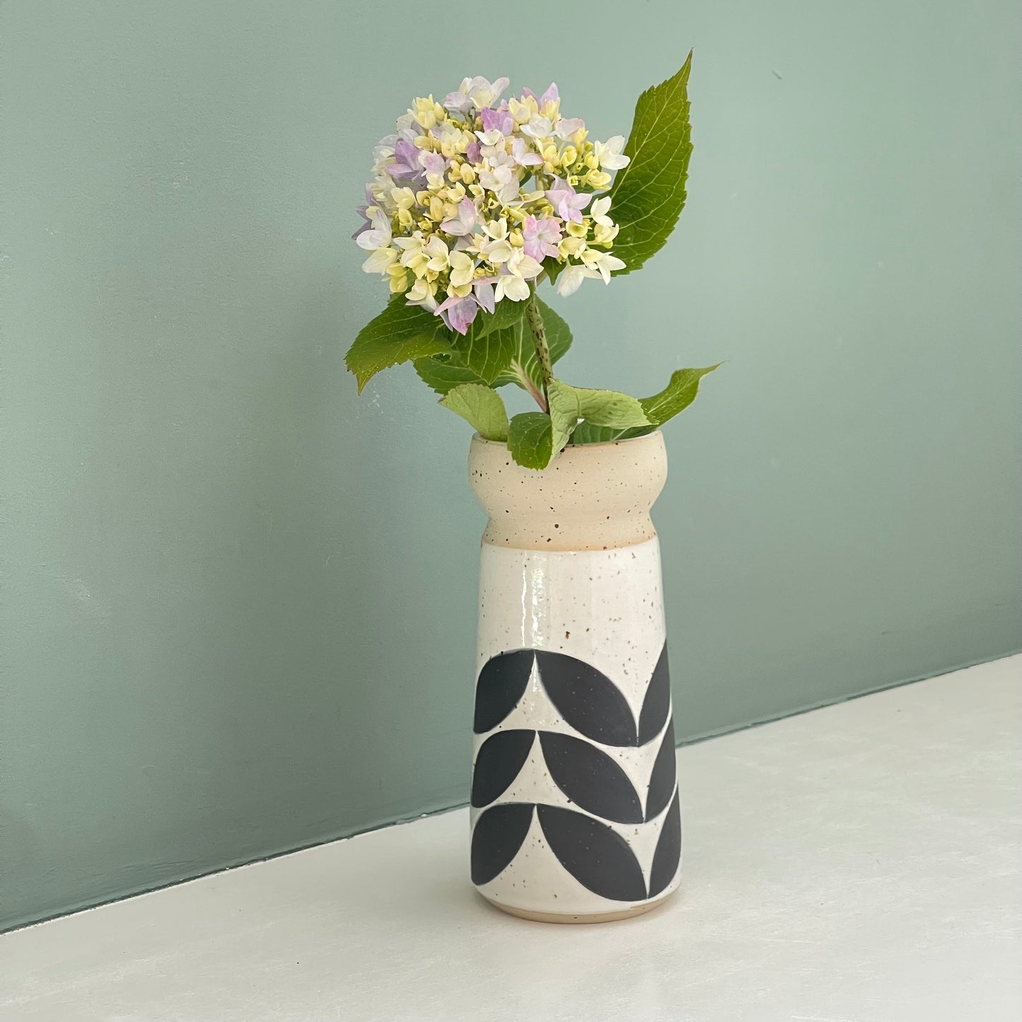 small vase, black leaves