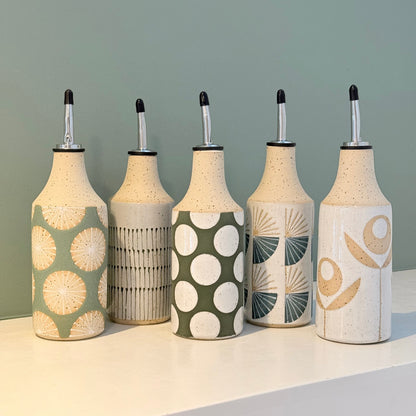 Set of five decorative bottles with unique patterns on a neutral background